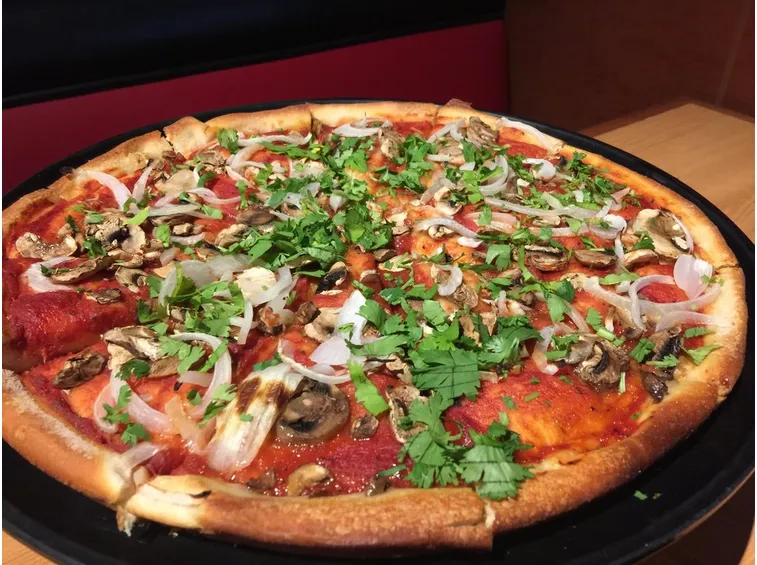 Pizza con pomodoro, funghi e prezzemolo